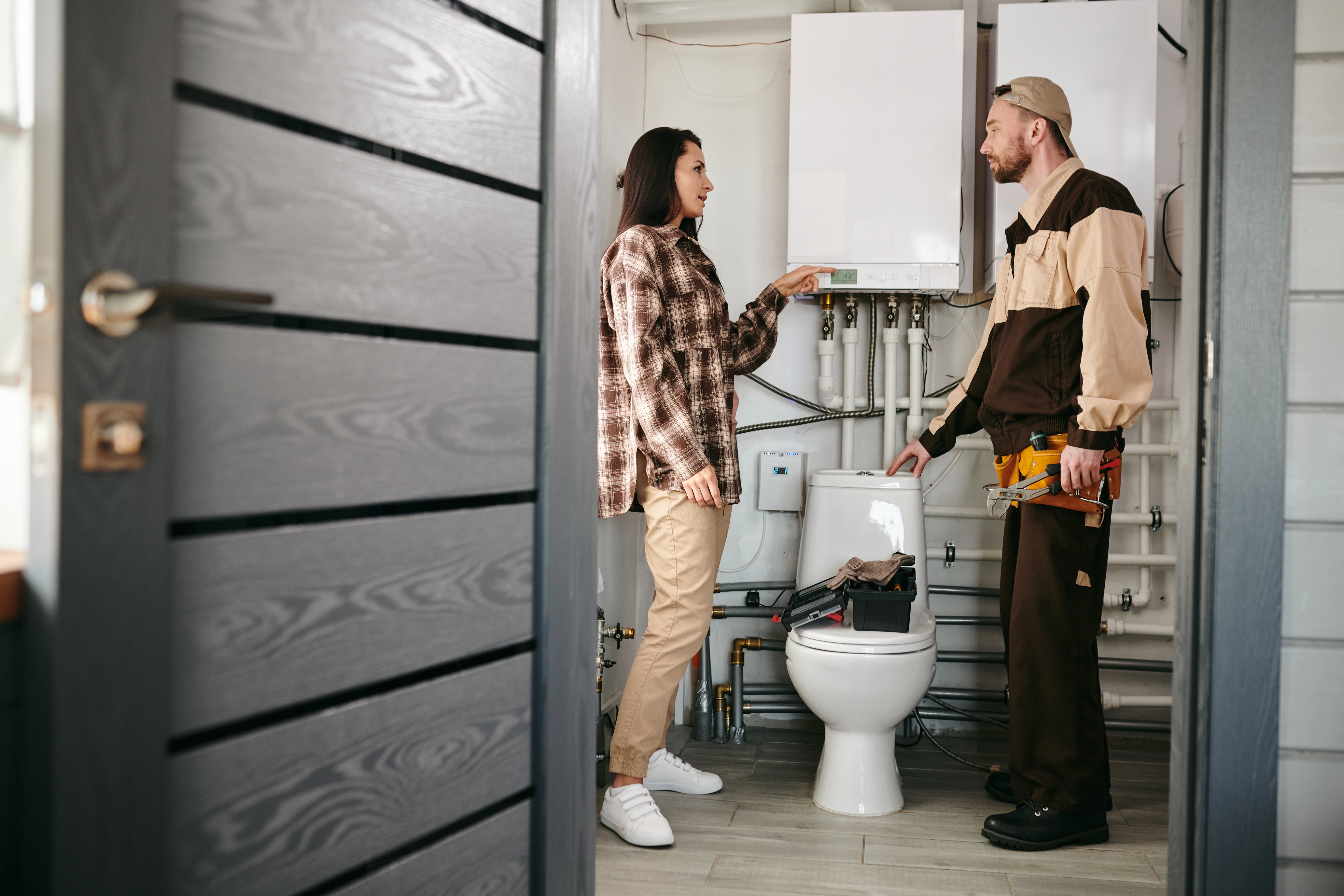 Professional plumber discussing plumbing options with homeowners in Fort Collins