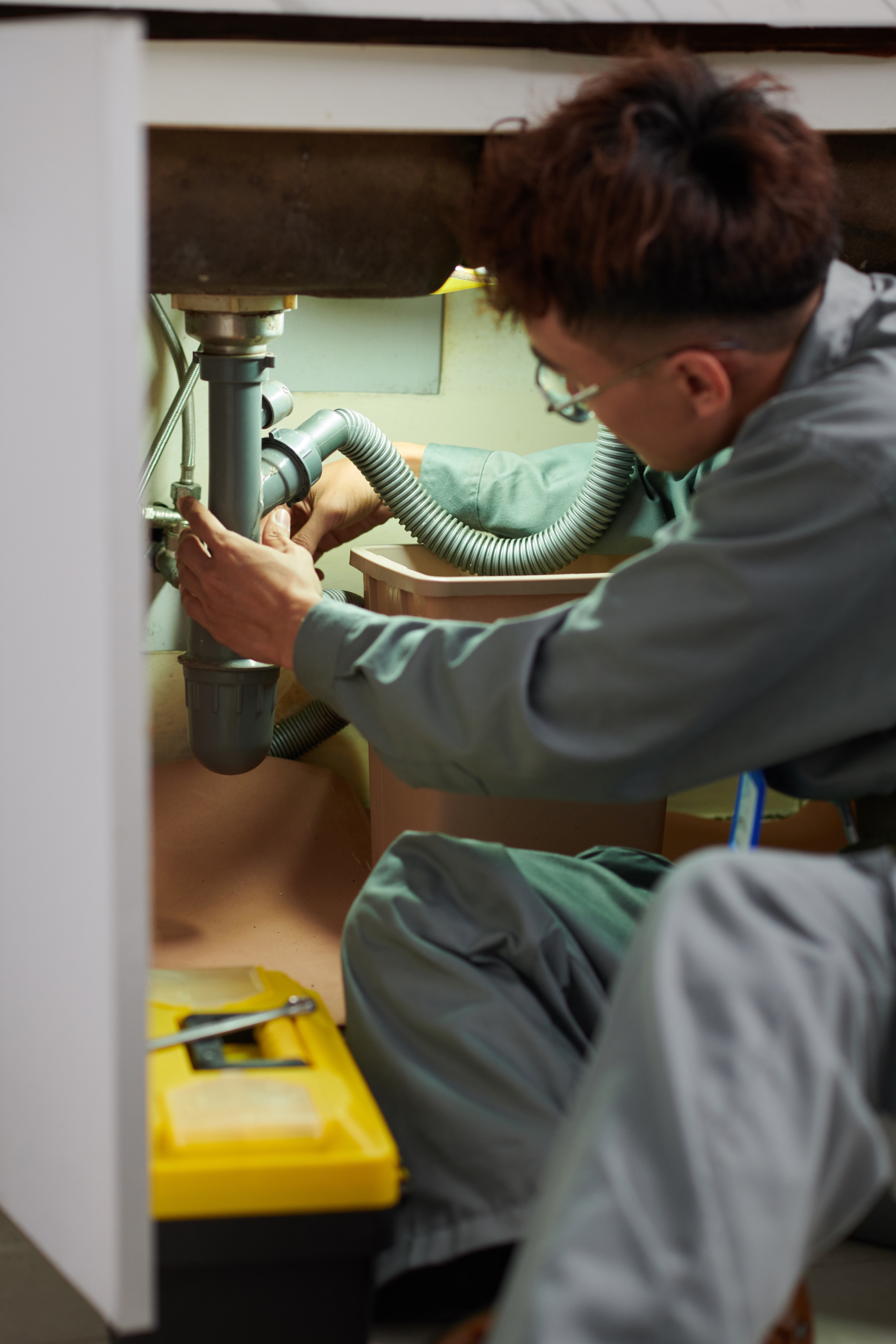Professional plumber unclogging a sink drain